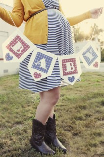 Pregnant Caucasian woman holding baby banner in backyard