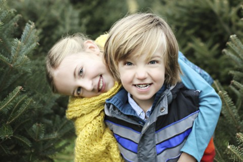 Siblings hugging near pine trees