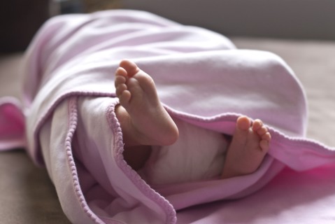Close up of feet of baby girl in blanket