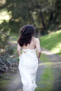 Rear view of bride walking on rural dirt road