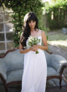 Bride holding bouquet of flowers in backyard