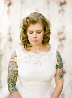 Close up of bride with tattoos wearing wedding dress