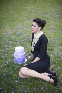 Woman sitting with cake in rural field
