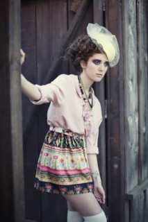 Stylish woman leaning on wooden gate