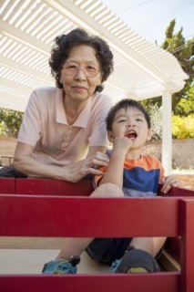Asian woman and grandson relaxing in backyard