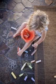 High angle view of girl drawing with chalk on tile