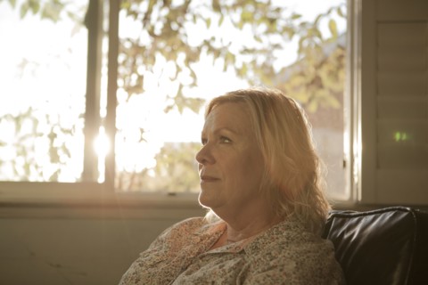Close up of older woman sitting near window
