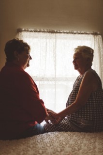 Older woman sitting with daughter on bed