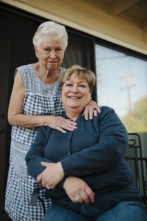 Older woman standing with daughter
