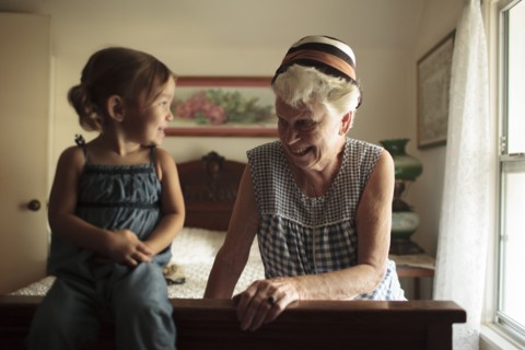 Grandmother and granddaughter playing on bed