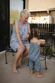 Grandmother and granddaughter playing on patio