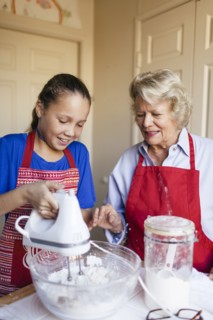 Grandmother and granddaughter baking in kitchen