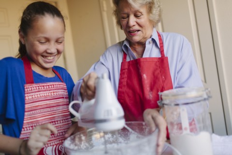 Grandmother and granddaughter baking in kitchen