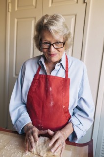 Older woman shaping dough in kitchen