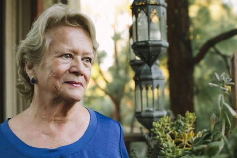 Pensive older woman standing on porch