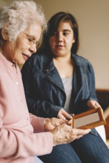 Grandmother and granddaughter admiring old photograph