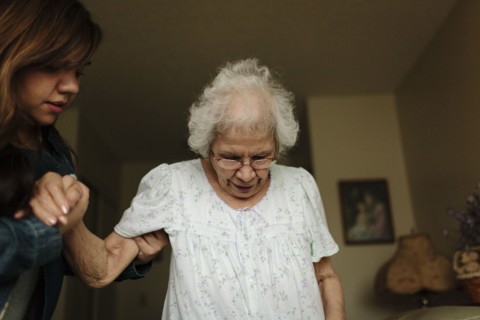 Granddaughter helping grandmother stand