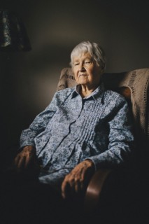 Older mixed race woman sitting in armchair
