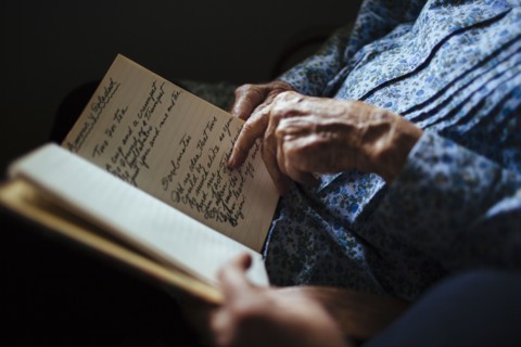 Older woman reading handwriting to granddaughter