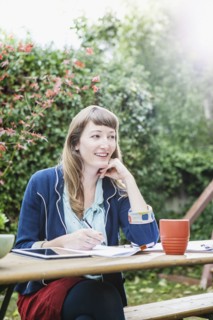 Mixed race businesswoman writing notes in backyard
