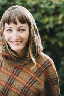 Mixed race woman wearing hood and shawl in backyard
