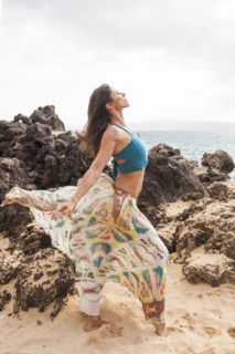 Woman dancing on rocky beach