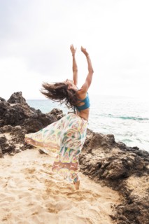 Woman dancing on rocky beach