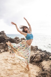Woman dancing on rocky beach