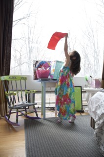 Caucasian girl playing in bedroom