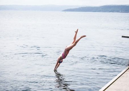 Caucasian girl diving into lake