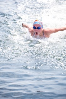 Caucasian swimmer gasping for air in lake