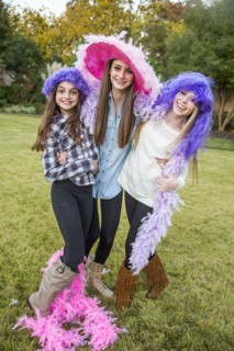 Caucasian teenage girls wearing feather boas and costumes
