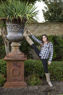 Caucasian teenage girl stretching leg in backyard
