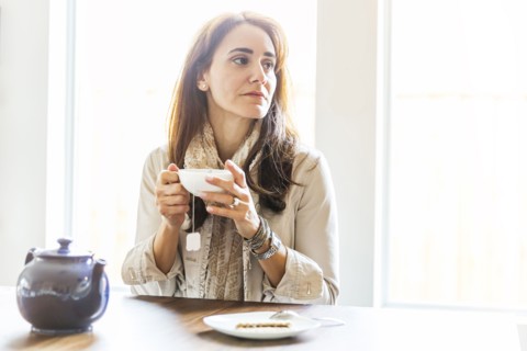 Caucasian woman drinking tea at table