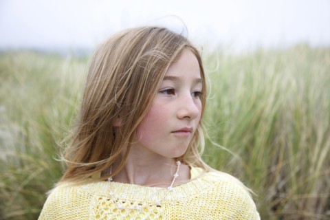 Mixed race girl standing in grass