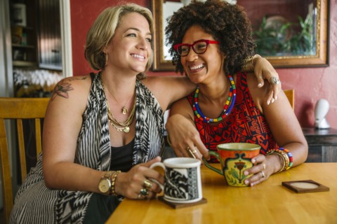 Hugging women drinking coffee