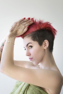 Caucasian woman styling dyed hair
