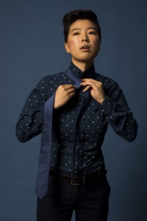 Androgynous woman tying tie