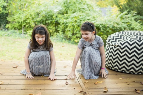 Twin sisters playing on deck