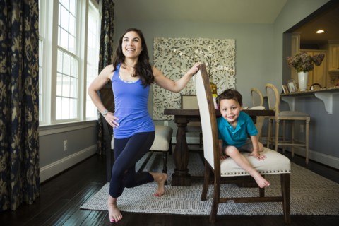 Mother stretching with son in dining room