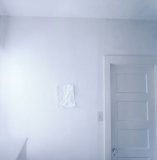Wrinkled paper on empty white wall