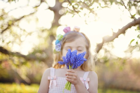 Caucasian girl smelling flowers outdoors
