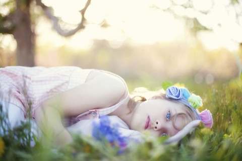 Caucasian girl laying in grass