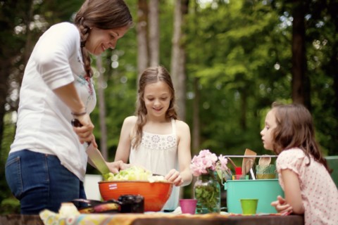 Caucasian mother and daughters cooking outdoors