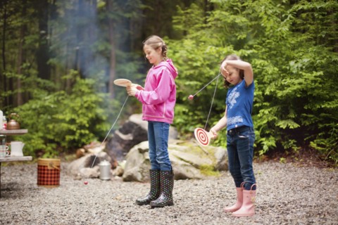 Caucasian girls playing with toys in forest
