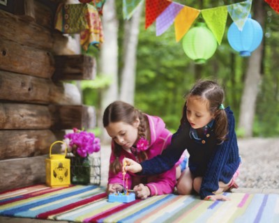Caucasian girls playing with toy on cabin porch