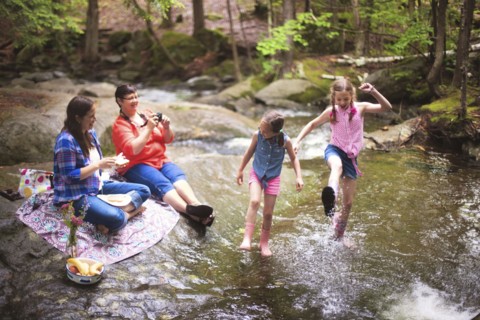 Three generations of Caucasian women playing in river