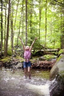 Caucasian girl splashing in river