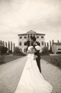Caucasian bride and groom kissing on gravel path