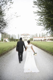 Caucasian bride and groom walking on gravel path